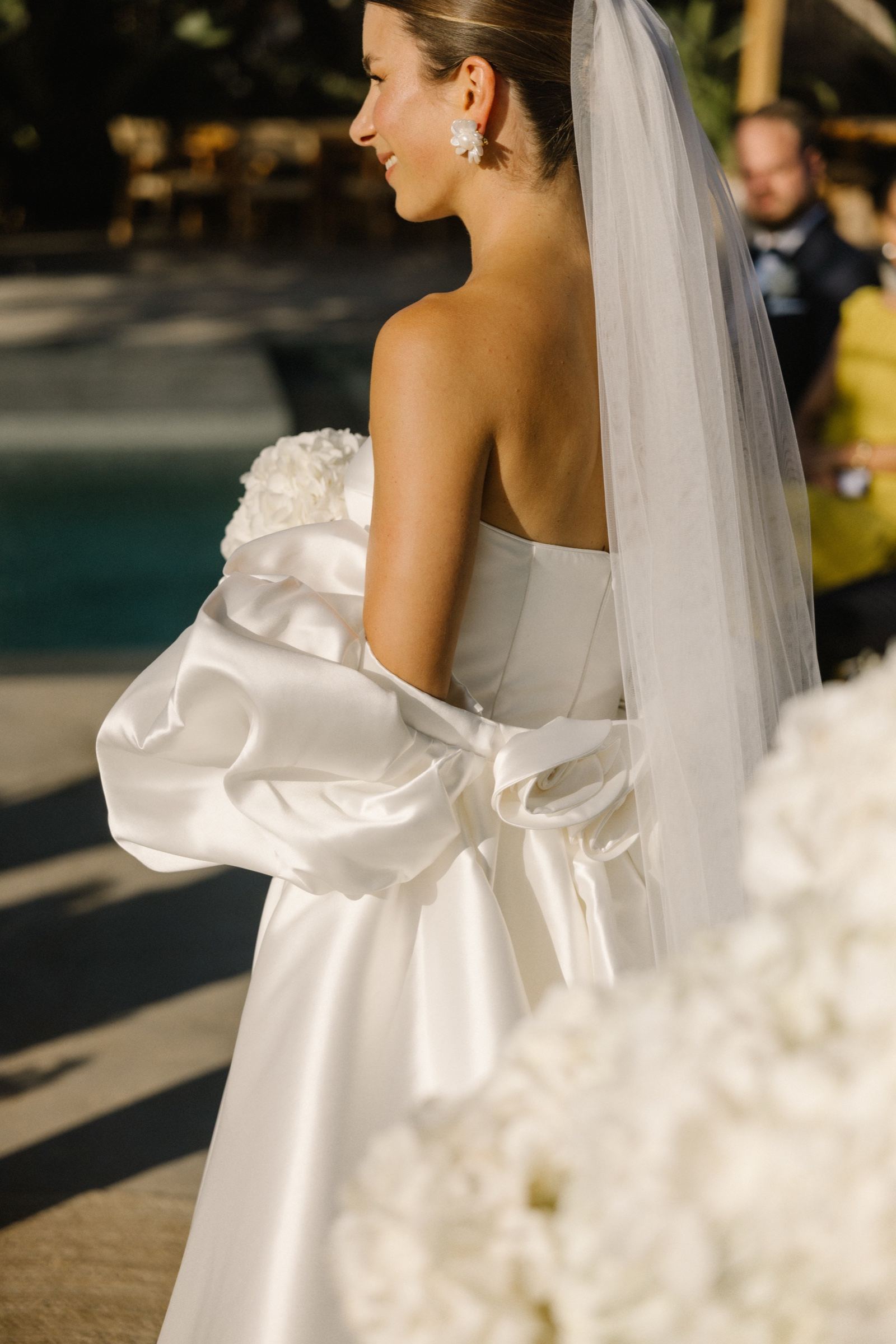 Bride from behind with veil and satin bow in evening light